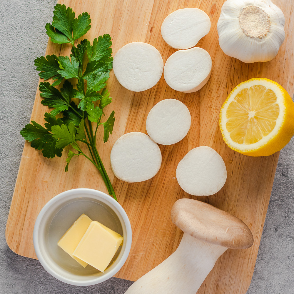 king oyster mushrooms and ingredients on a cutting board
