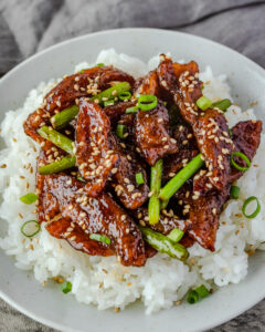 an image of vegan mongolian beef over white rice