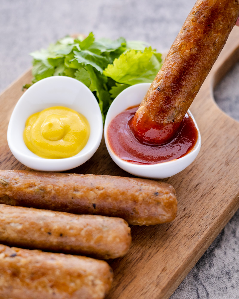 an image of vegan sausages with ketchup