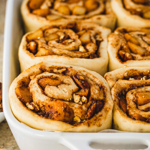 an image of vegan apple cinnamon rolls in a baking dish